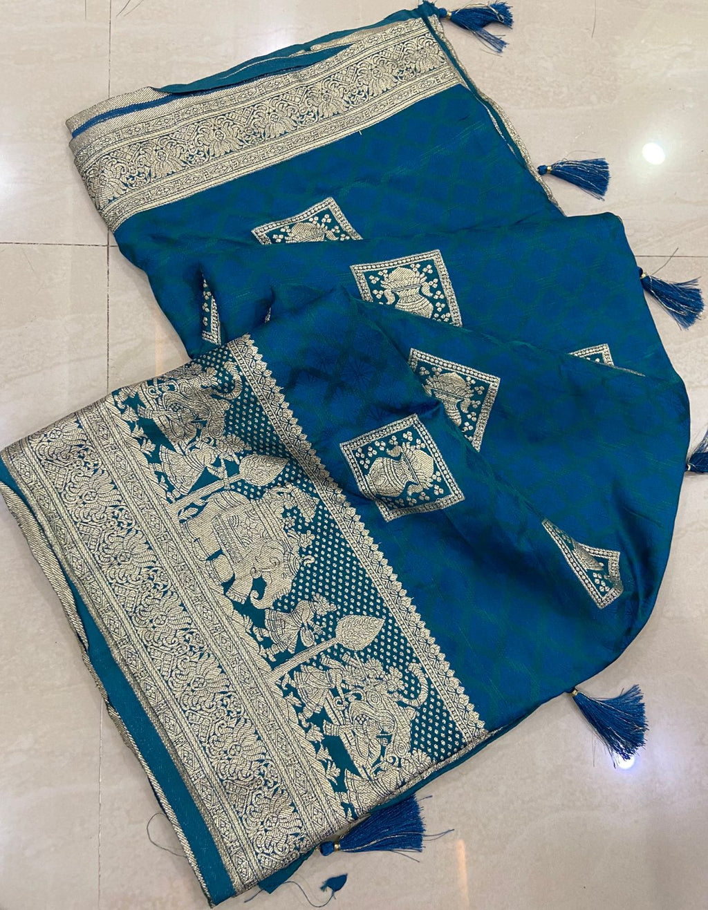Blue saree with white patterns on a tiled floor