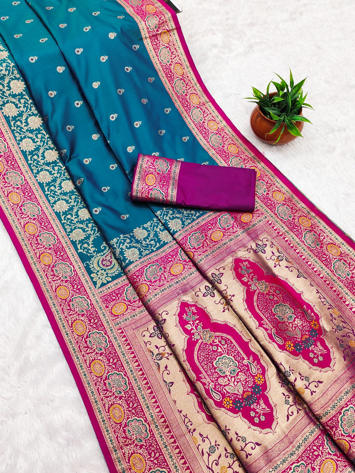 Pink and blue saree with intricate patterns on a wooden background