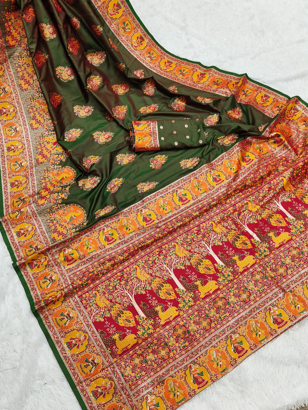 Green saree with colorful elephant patterns on a white background