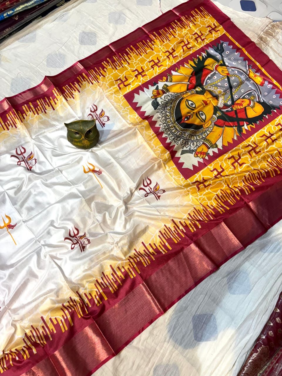 Decorative piece with Maa Durga as a central figure and intricate patterns on a white background