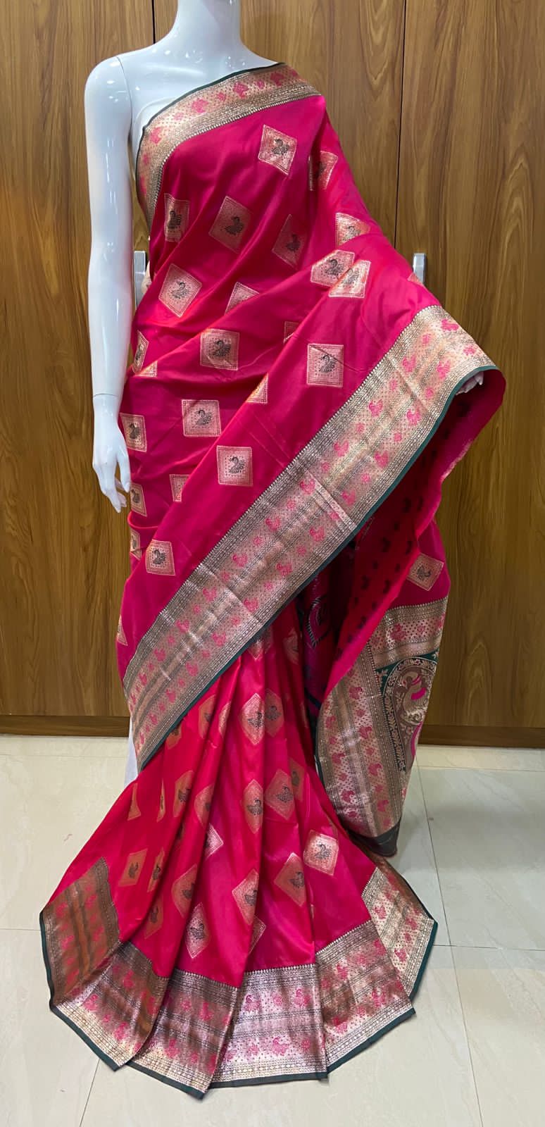 Pink saree with intricate patterns on a wooden background