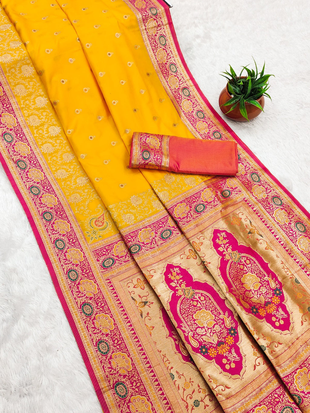 Traditional saree with yellow and pink patterns on a white background