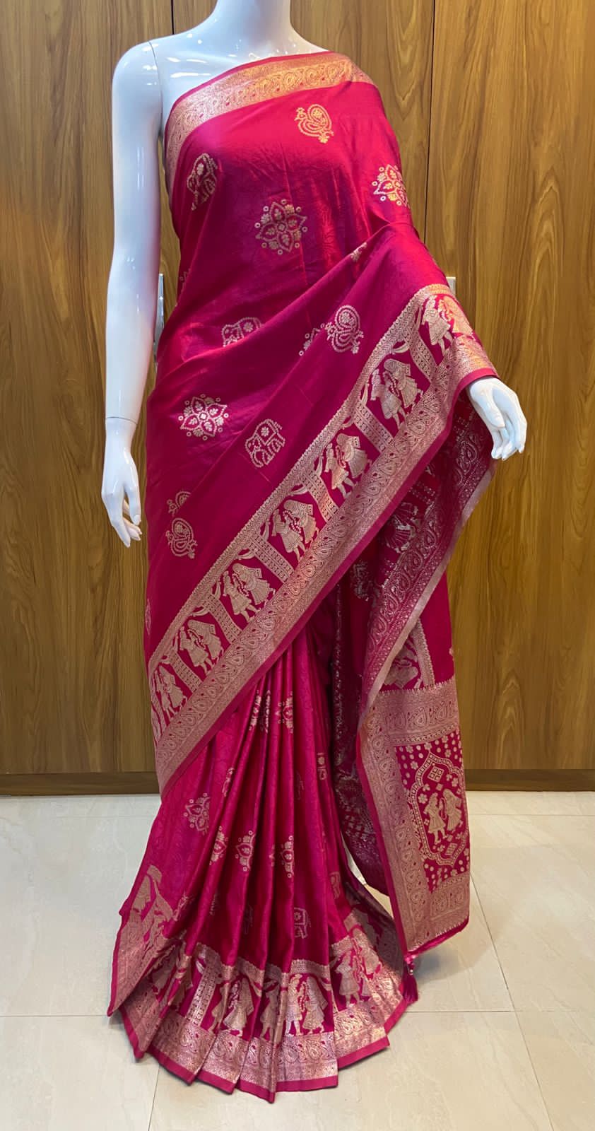 Red saree with gold patterns on a wooden background