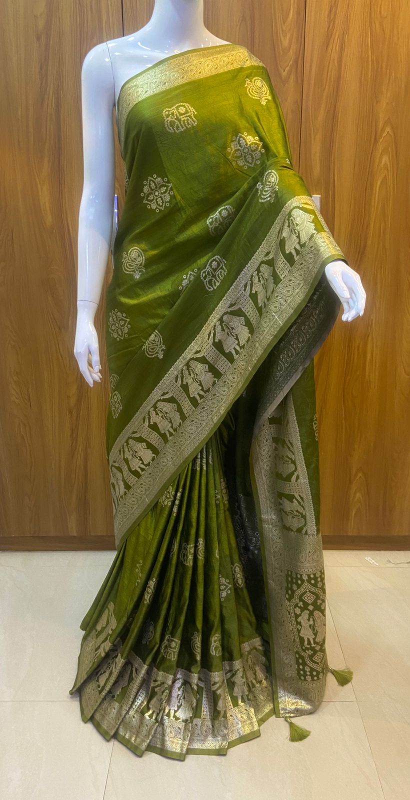 Green saree with gold patterns on a wooden background