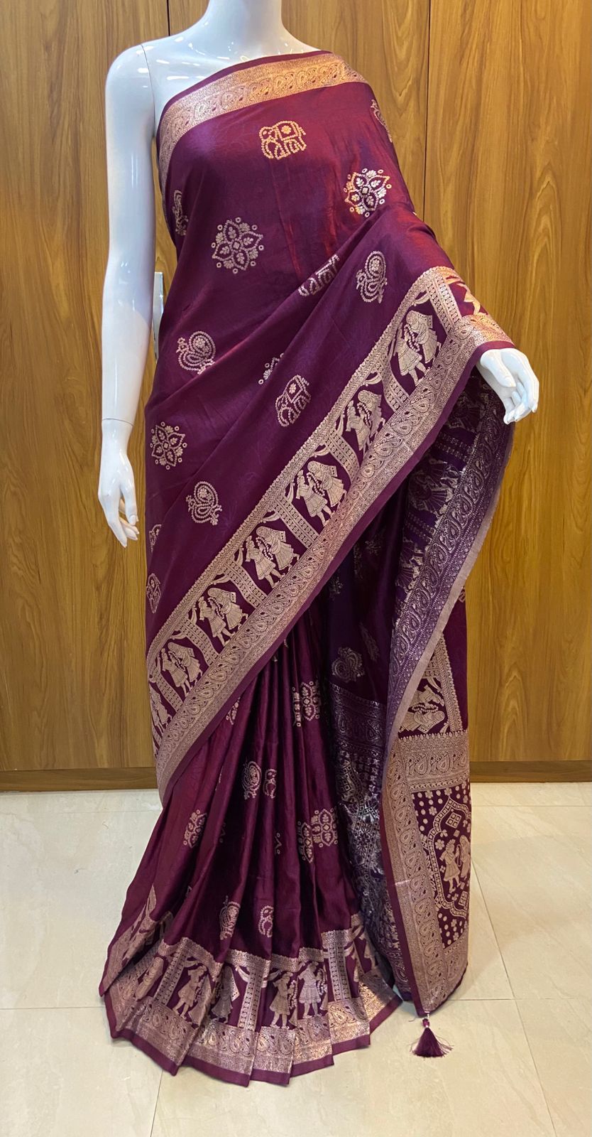 Maroon saree with gold patterns on a wooden background